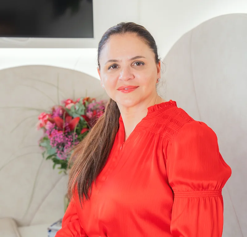 Doctor-medic Gabriela Bankos in einem weißen Sessel, lächelnd